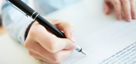 Hand die met een pen een document ondertekent