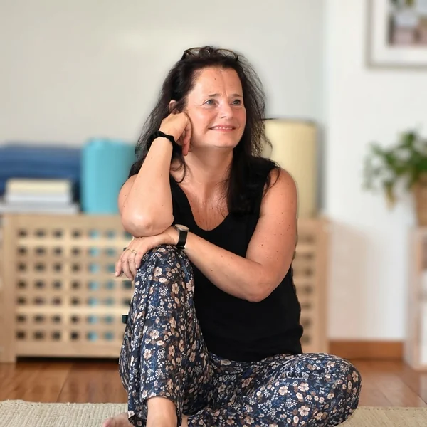 Paula Damen-van Eijk zit op de grond in de praktijkruimte